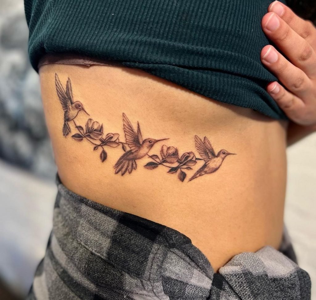 flock of hummingbird tattoo on side of stomach