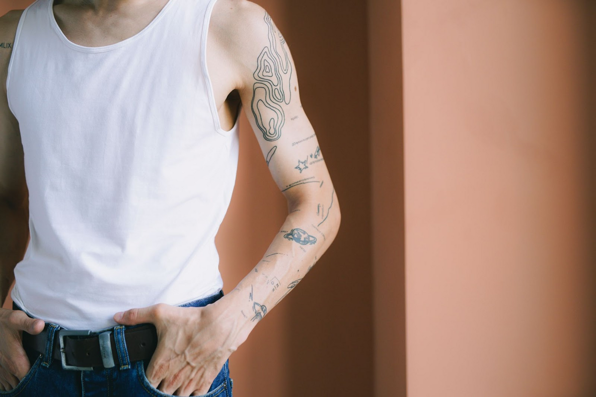 caucasian male with small planet forearm tattoo