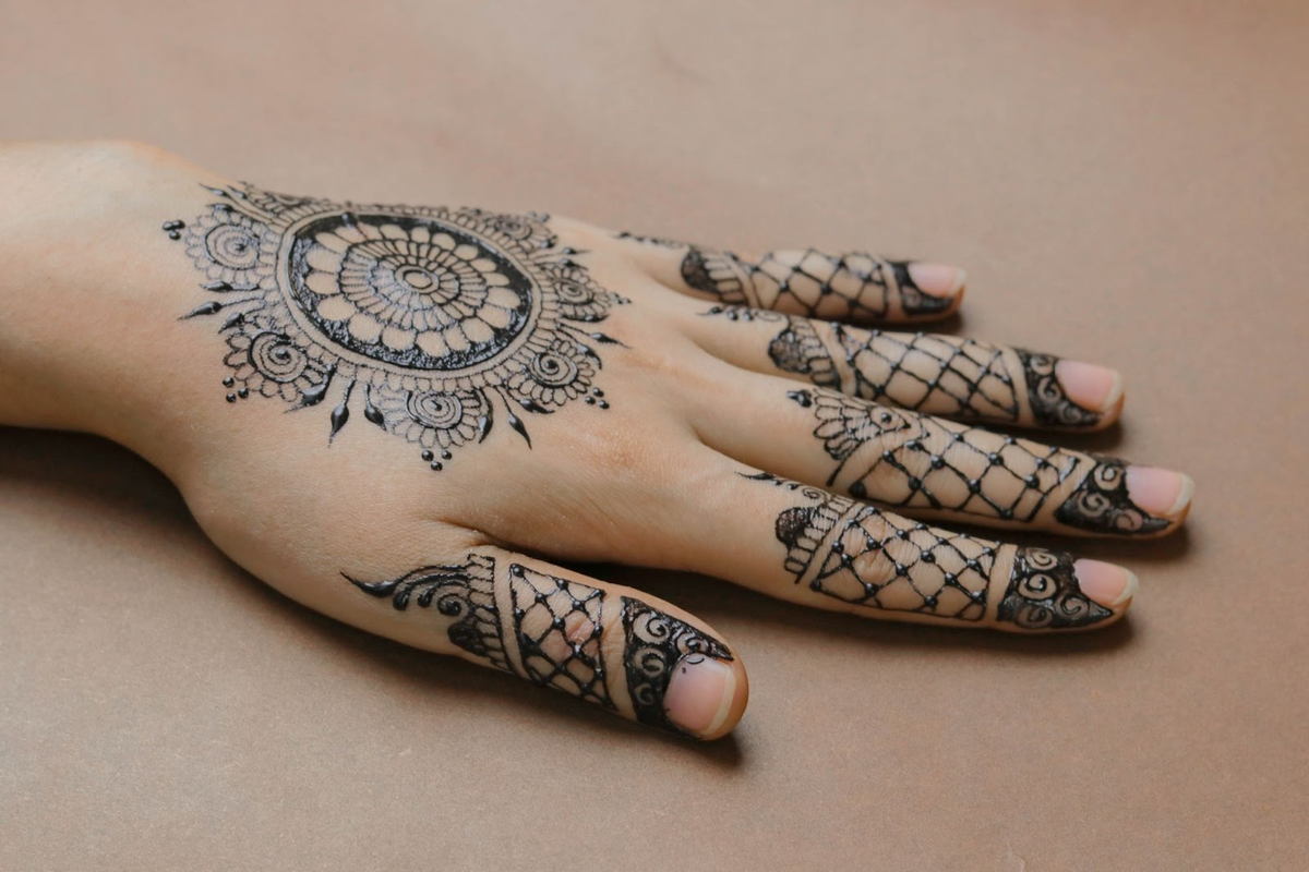 detailed finger tattoo in henna method on left hand