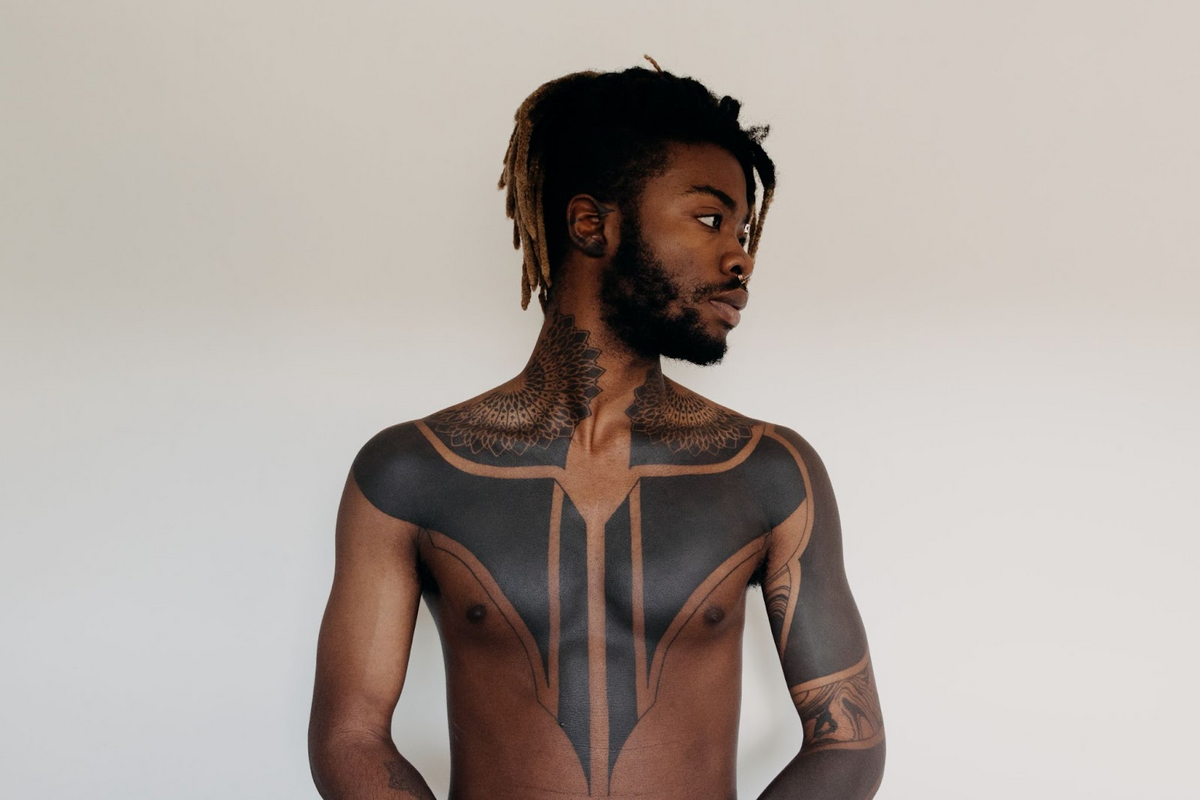 man with block chest tattoo and tribal pattern shoulder tattoo
