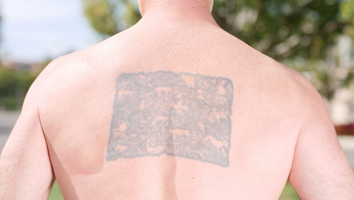 man with faded spine tattoo